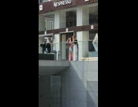Two women tiktok dance in front of the Nespresso building