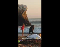 Woman red top toss sand backwards beach