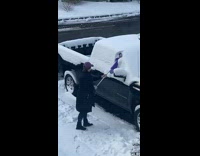 Woman uses Swiffer to wipe of snow 