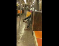 Girl rubs foot brown boots pink mask 