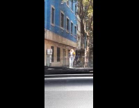 Woman blonde hair with a jacket poses at the sidewalk