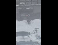 Guy wearing a kilt and a top hat to shovel snow on sidewalk 
