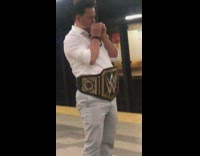 Guy with gold watch and chain wears WWE wrestling belt at subway station