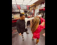 Couple dances in pizza parlor with music