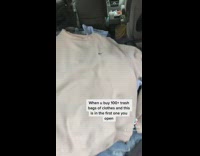 Opening trash bag of clothes and finding vintage white nike sweater