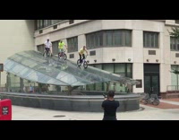 Four guys ride bicycles subway entrance roof 