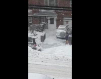 Guy shoveling snow blocks parked black car 
