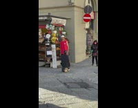 Man in red top poses near fruit store