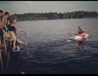 man in red jet ski pulls guy on dock pier 