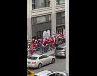 People dressed as Santas wait in line outside pt 2
