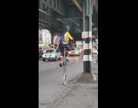 Guy balancing and riding a unicycle on road