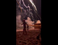 Man films family with fireworks at beach
