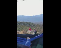 Woman hold fluffy red dress over rock