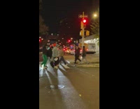 Guy sings into microphone while crossing street