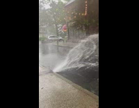 Sewer hole splashes water onto street flood 