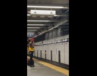 Man waits at the subway while heavy flood 