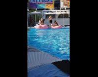 Two women bikini flamingo floater pool party