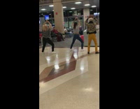 Three girls dancing in airport waiting area