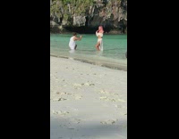 Woman with pink hair and white dress dance at the beach