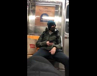 Guy riding subway train adjusts black pants 