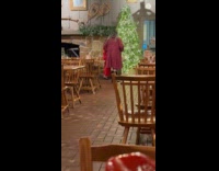 Woman teaches daughter pose beside Christmas tree