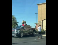 Two girls sit over black truck chickfila