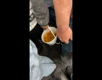 Guy on subway carrying a bucket of fried chicken and fries 

