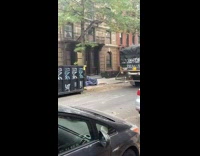 Truck pulls black dumpster down street graffiti 