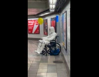 Mummy in wheelchair waits at subway station