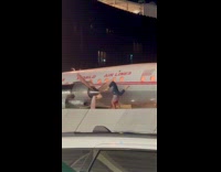 Woman doing yoga on wall divider at airport arrivals