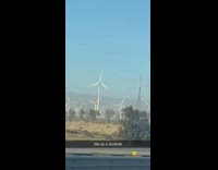 Car drives by broken windmill freeway highway 