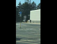 Woman blue jacket scarf walks towards camera for a picture 