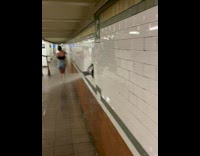 Woman walks under water leak in subway walls 