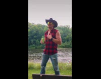Cowboys lip sing to song next to lake 