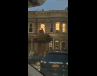 Guy Barbecues Inside with Grill on Balcony 