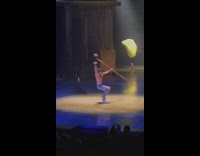 Dancer spins and lifts with stick 