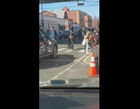 Person wearing batman costume walks across street