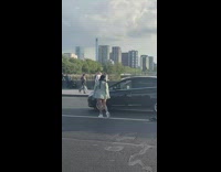 Woman in green checkered coat poses at the street