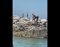 Guy climb on rock and twerk beach