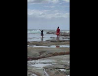 Woman grey dress double peace sign beach