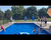 Men jumps passes ball shoots at pool