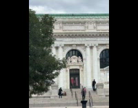 Woman in sunglasses poses outside Apple Carnegie Library