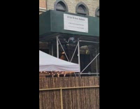 Little boy climbs scaffolding bar restaurant patio 