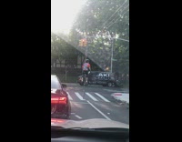 Guy in helmet on tall unicycle biking in the streets between traffic