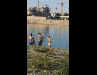 Man shirtless flexes muscle in the beach