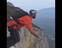 man orange jacket jumps cliff