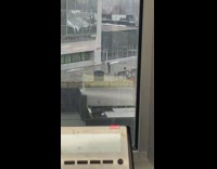 Man grey jacket dance outside building bench