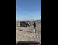 Guy black jacket SUV rocky terrain mountain