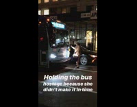woman stands in front of a bus in the night