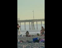 Man kneel remove shirt beach sunset music